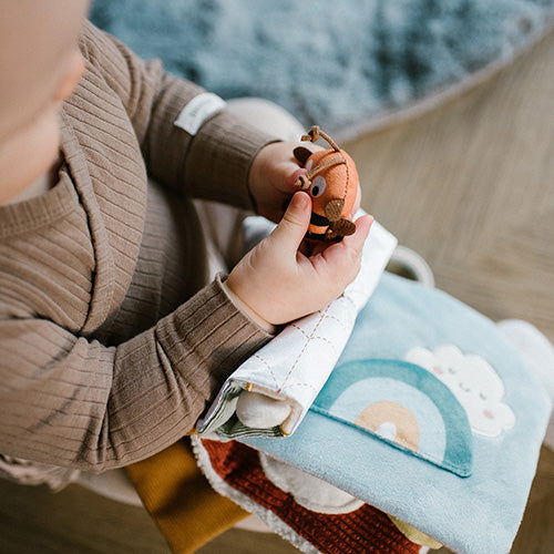 Dziecko bawiące się książeczką sensoryczną "Nature" od Babyono.