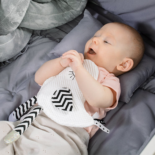 Dziecko bawiące się zabawką sensoryczną "Little Birdie Blink & Smile"