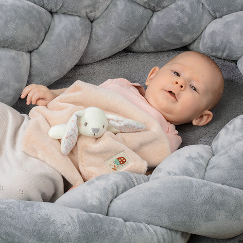 Dziecko leżące w łóżeczku z przytulanką - kocykiem "Baby Bunny" od Babyono.