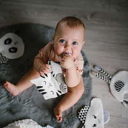 Dziecko bawiące się zabawką sensoryczną "Kitty Blink & Smile" od Babyono.