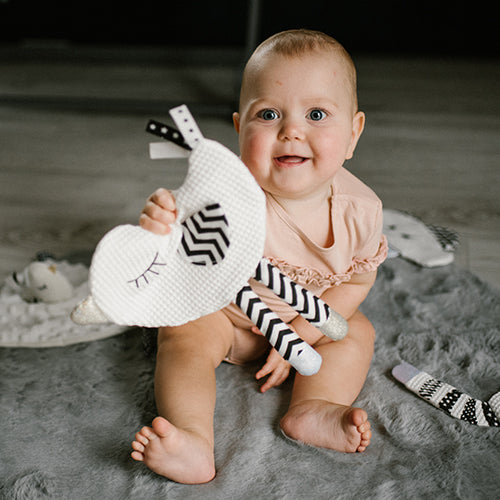 Dziecko bawiące się zabawką sensoryczną "Little Birdie Blink & Smile"