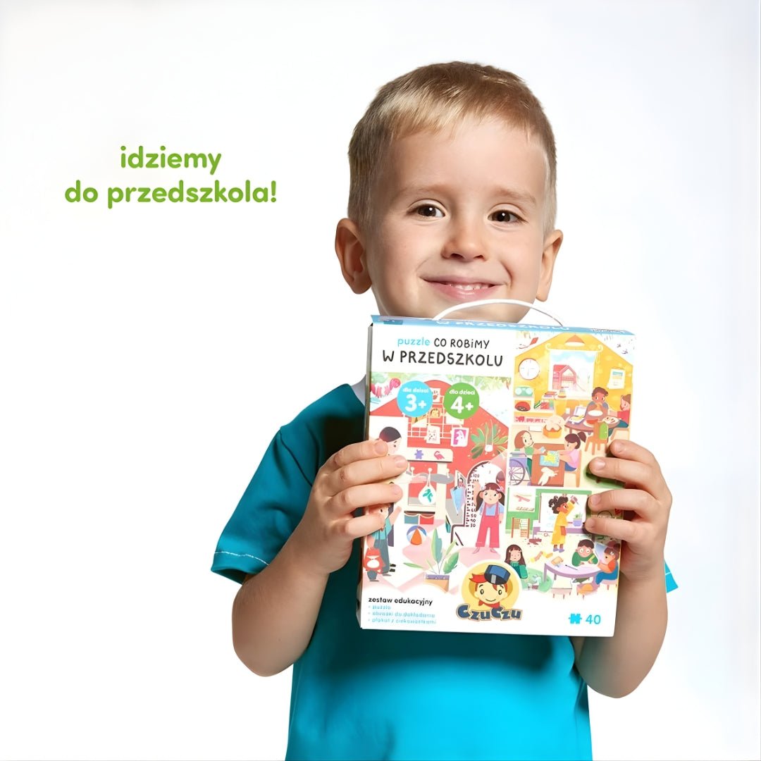 Pudełko puzzli CzuCzu Co robimy w przedszkolu trzymane przez chłopca - edukacyjna zabawa dla przedszkolaków.