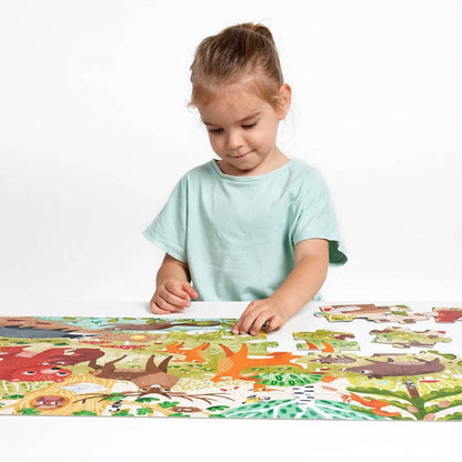 Dzikie puzzle Las CzuCzu dziecko układające puzzle przy stole.